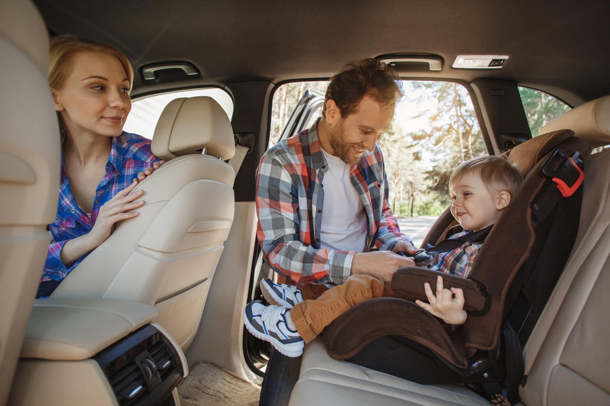 Parents buckling their child in a car seat. Another car hack for moms. 