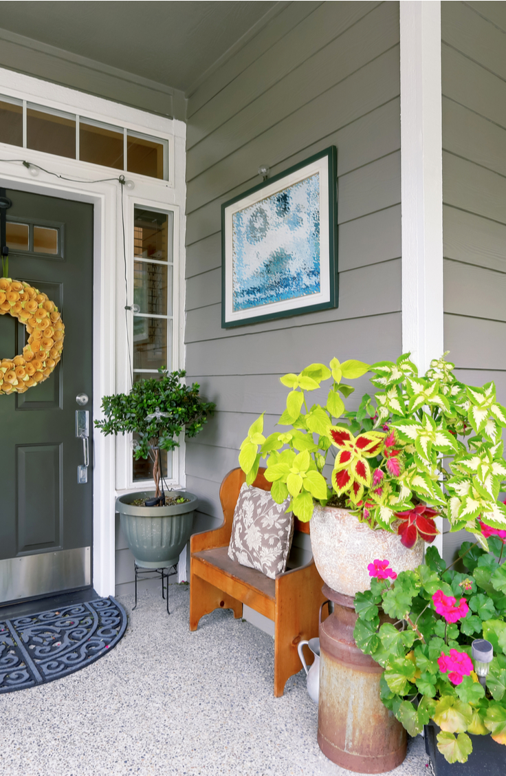 Spring Decorating Ideas- A front porch with spring decor. Gorgeous pink geraniums, coleus, milk can, wreath on front door.